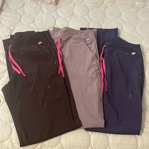 Three pairs of Tall XS smitten bootcut scrub pants.